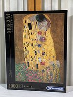 Front view of the puzzle box showing the artwork "The Kiss" by Gustav Klimt and the Clementoni Museum Collection branding, highlighting the 1000-piece puzzle count.