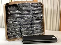 Lot of multiple black protective cases in original cardboard box, individually sealed in plastic bags.