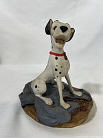Front view of the Pongo figurine showing the dog's joyful expression, collar, and base details.