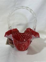 Front view of Fenton cranberry glass basket with red hobnail glass and ruffled white edge, featuring a twisted clear glass handle.