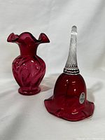 Cranberry glass bell and bud vase displayed on white background showing texture and ruffled edges