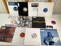 13 vinyl LP albums arranged flat on a surface, showing album covers and labels from various house music records.
