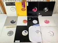 Overview of 12 house music LP vinyl records mostly in plain white, black, grey, and yellow sleeves showing condition and label details.