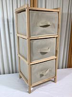 Full view of the wood rack with three beige canvas drawers inserted.