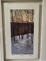 Close-up of the watercolor painting on textured paper, showing detail of branches, snow, and sunset sky. Visible signing and numbering below image.