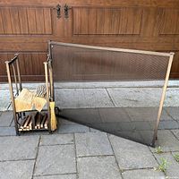 Photo showing the fireplace screen, metal wood holder with firewood, and broom attached to holder.