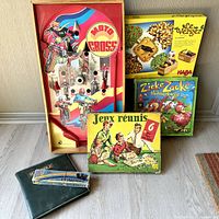 Photo showing the Italian wood frame Moto Cross pinball game and three boxed board games by HABA (Le Verger and Zicke Zacke Hühnerkacke) and Jeux Réunis multi-game board.