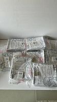 10 packs of giant coloring sheets in sealed plastic packaging, stacked on floor.