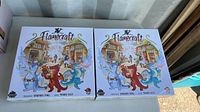 Two brand new sealed boxes of Flamecraft board game French edition, front cover showing village and dragons artwork.