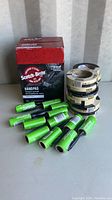 Photo of a box of Scotch-Brite Hand Pads, several green-handled lint rollers, and rolls of 3M tape stacked beside the box.