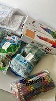 Photo showing DIY painting kits, colored pencils, coloring sheets, and bags of game pieces.