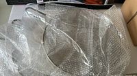 Three splatter free microwave covers, clear plastic, displayed with bubble wrap