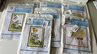 Front view showing seven Joy Sunday cross stitch kits in unopened packaging, featuring children-themed designs.