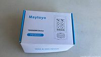Closed retail box showing the Maytoyo branding and model number FM-B2407 with a line drawing of the device on the front.