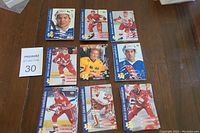 Nine 1994 World Junior Hockey cards laid out in three rows, showing various players in red, yellow, and blue jerseys.