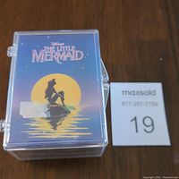 Front view of The Little Mermaid 1991 card set in clear plastic protective case showing title and illustrated mermaid silhouette.