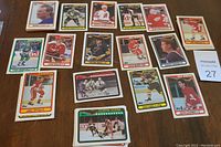 Photo showing 18 Topps 1990 NHL hockey cards laid out on table with visible player images, team names, and some stacks of cards