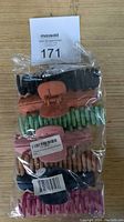 Photo of 7 hair claw clips in assorted colors, sealed in original plastic packaging with MaxSold lot card.