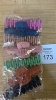 Front view of packaged 7 hair claw clips in matte colors including pink, navy blue, beige, green, rusty orange, black.