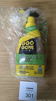 Front view of the Goo Gone Grout & Tile Cleaner spray bottle in clear plastic wrapping, showing label with brand and product name and yellow trigger.