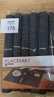 Set of six black placemats with textured crossweave design in original plastic packaging with label showing 'PLACEMAT Size 45X30CM 6pcs'