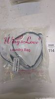 Packaged white mesh laundry bag with zipper and Wingslove branding on the packaging.