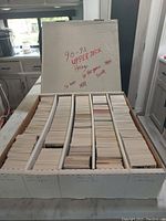 Top view of a white storage box filled with thousands of Upper Deck hockey cards, cards arranged in multiple rows filling the full capacity.
