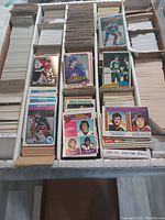 Five cardboard index card storage boxes filled with rows of hockey cards sorted by handwritten dividers labeled by seasons