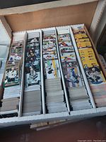 Box opened displaying 5 rows filled densely with hockey trading cards including some with yellow divider sheets