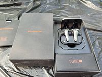 Photo of Monster Mission V1 wireless earbuds in charging case inside open original box along with box lid and informational booklet
