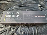 Black rectangular box of Vaslon One Step Hair Dryer and Styler showing text about functions: straightening, diffusing, hot air brush.
