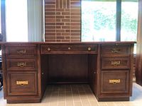 Front view of desk showing two filing cabinet drawers on each side and central knee space