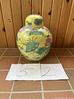 Front view of the large vintage ginger jar with lid on, showing yellow background and colorful hand-painted water lilies.
