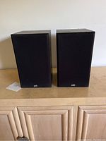 Front side showing pair of PSB 300 speakers with grilles on, logo at bottom center.