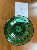 Top view photo showing the round emerald green glass bowl with detailed diamond and starburst pattern at bottom and sides.