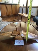 Photo showing the full carved sculpture including lily pads and stems with a measuring tape indicating height about 14 inches.