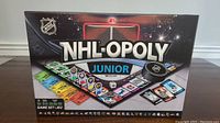 Front view of the NHL-OPOLY Junior board game box showing branding and artwork of the game board and pieces.