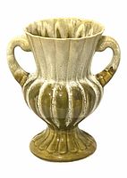 Front view of the ceramic pottery vessel, showing its double handles, ribbed body, and fluted pedestal base with mottled green and brown glaze finish.