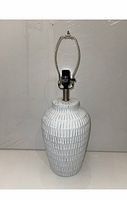 Full view of the white ceramic textured lamp showing its shape, texture, and harp.