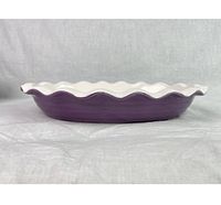 Side profile photo showing deep purple exterior with white wavy rim edges on ceramic dish