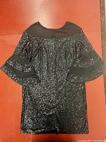 Front view of the black sequin cocktail dress showing sheer mesh neckline and tiered bell sleeves with mesh inserts.