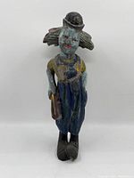 Front view of the painted carved wooden clown figurine showing details of the face, hat, and overall outfit.