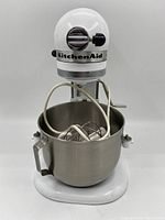 Front view of vintage KitchenAid stand mixer with bowl and attachments inside bowl.