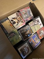 Box containing mixed audio CDs laid flat showing front covers