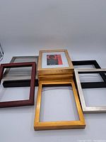 All eight 8x10 picture frames arranged with some stacked and some side-by-side. Varied colors include gold, black, silver, and wood tones.