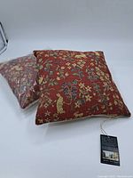 Two cushions, one wrapped in plastic and one unwrapped, on a white background