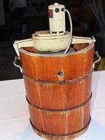Full view of White Mountain electric ice cream maker on white background, showing wooden barrel bucket and motor unit on top.