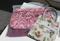 Photo showing the Thirty-One craft bag with pink, purple, and red floral abstract print and flap with logo.