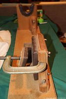 Side view focusing on the C-clamp style vise with padded clamps holding wood surfaces. Shows the screw mechanism.