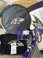 Photo showing round black cooler bag, cloth drink holders, and folding chair with Baltimore Ravens logos and colors
